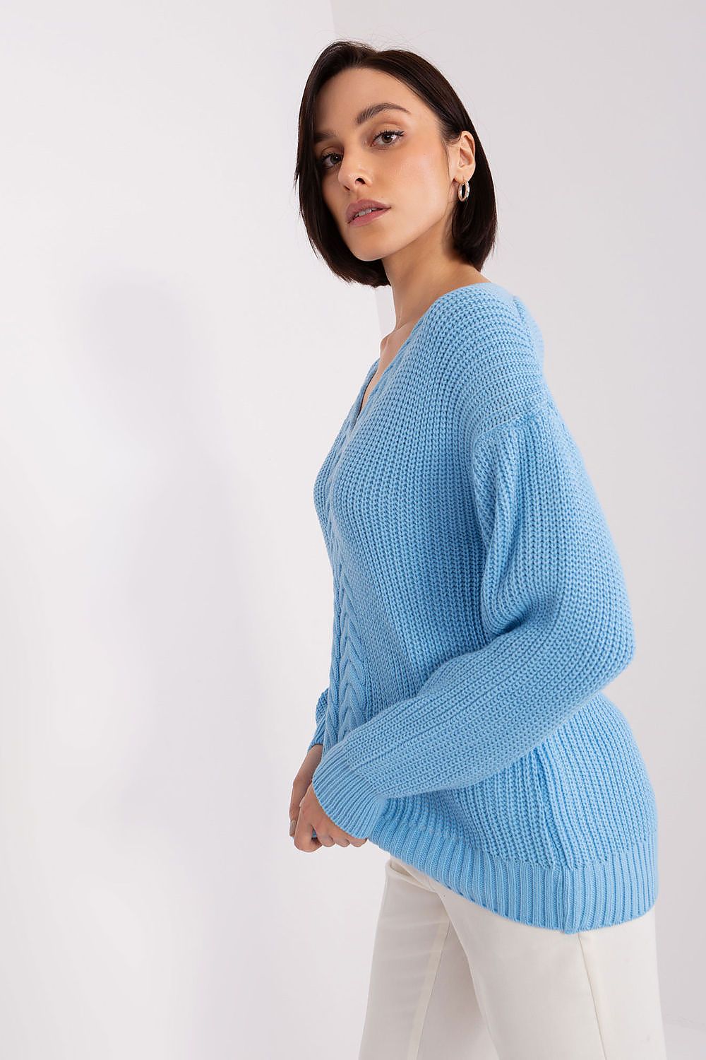 Elegant braided knit cardigan in a serene sky blue color, featuring a stylish woman posing against a plain white background.