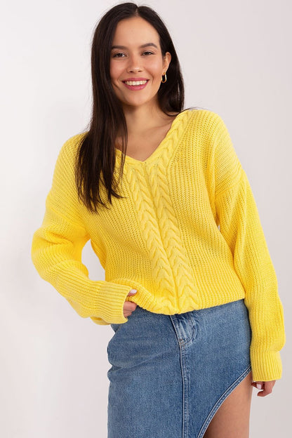 Radiant yellow cropped knit sweater by Badu brand, worn by a smiling woman with long dark hair against a plain background.