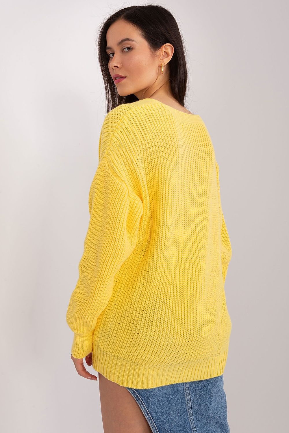 Radiant yellow cropped knit sweater with stylish ribbed texture, showcased on a model with long dark hair against a plain background.