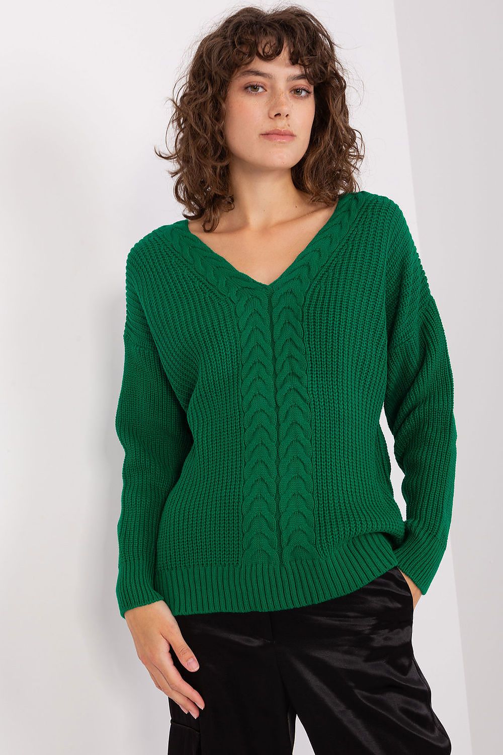 Cozy green cable knit pullover sweater modeled against a plain background