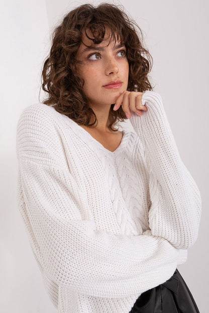 Elegant textured white sweater on a curly-haired model against a plain background