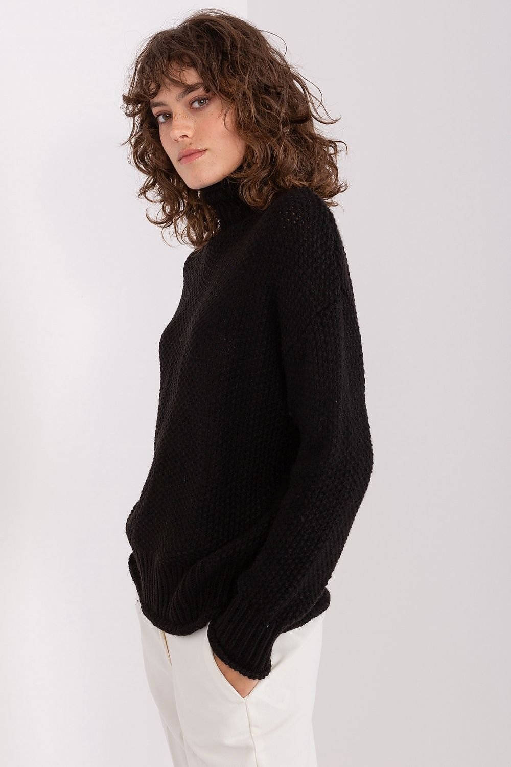 Cozy chic black turtleneck sweater by Badu, featuring soft, textured knit fabric and stylish curled hair