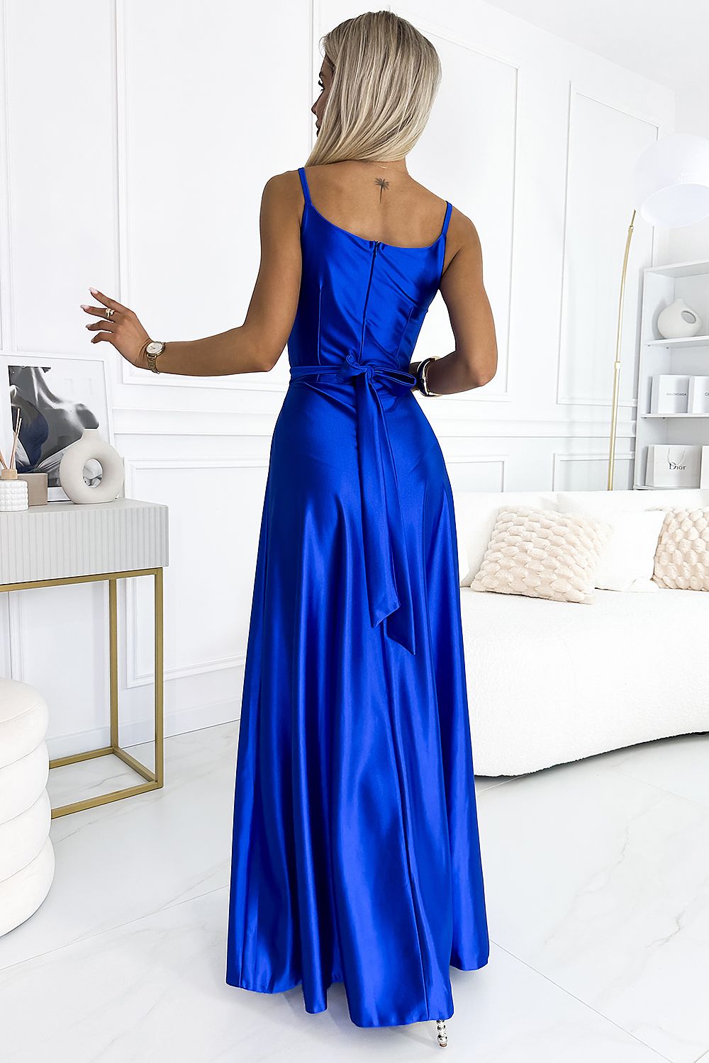 Elegant blue long dress by Numoco, worn by a woman in a stylish bedroom setting