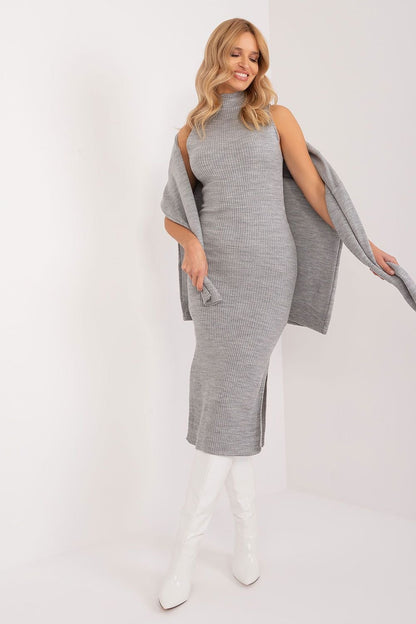 Elegant Sleeveless Midi Dress With Overlay
A woman in a gray knit midi dress with a stylish overlay, posing confidently against a plain background.