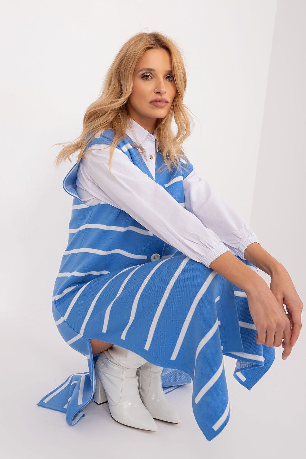 Elegant striped midi dress in blue and white tones, worn by a young female model with long wavy blonde hair.