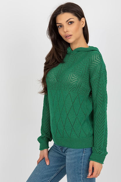 Emerald green crewneck sweater with textured diamond pattern, worn by a young woman with long dark hair against a white background.