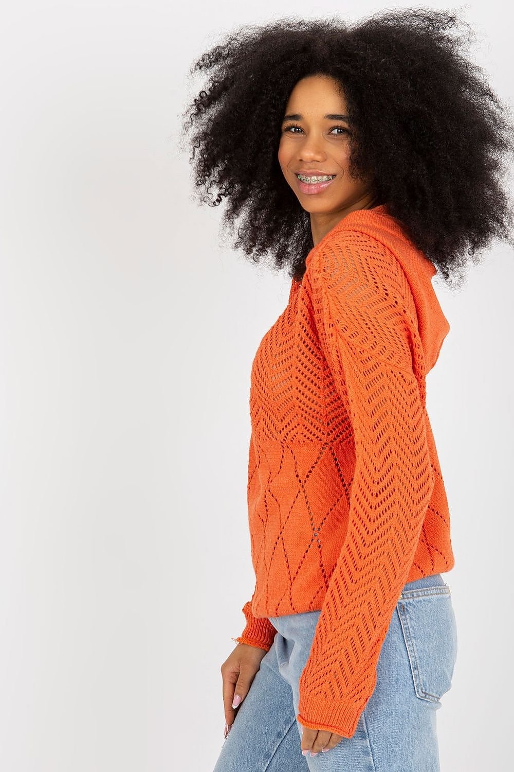 Cozy chenille orange crewneck sweater on smiling woman with curly dark hair