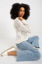 Load image into Gallery viewer, Elegant woman with curly dark hair wearing a cozy white knit sweater and blue jeans.