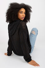 Load image into Gallery viewer, Elegant woman in black pullover with textured sleeves and distressed denim jeans