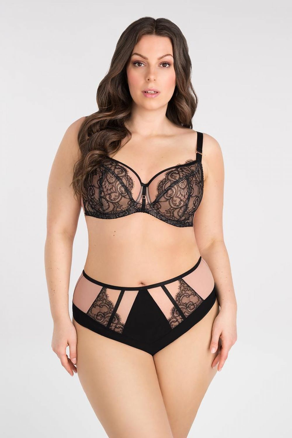 Elegant black lace undergarment set featuring a bralette and high-waist panties on a fashion model against a plain background.