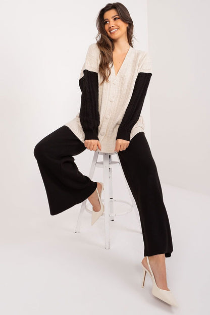 Cozy chic cable knit sweater with faux fur trim, worn by a smiling young woman on a white background.