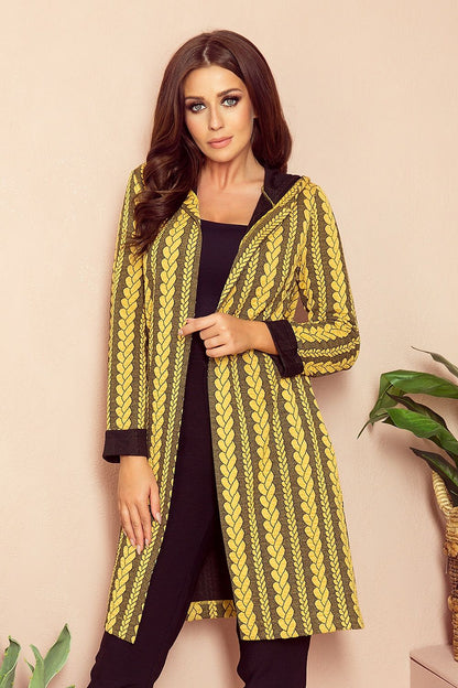 Elegant knitted mustard yellow cardigan with intricate patterns, worn by a stylish woman with long brown hair posing against a plain background.