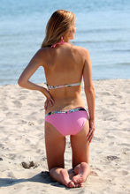 Load image into Gallery viewer, Stylish two-piece swimsuit with colorful pattern details on a woman&#39;s back, sitting on the beach by the ocean.