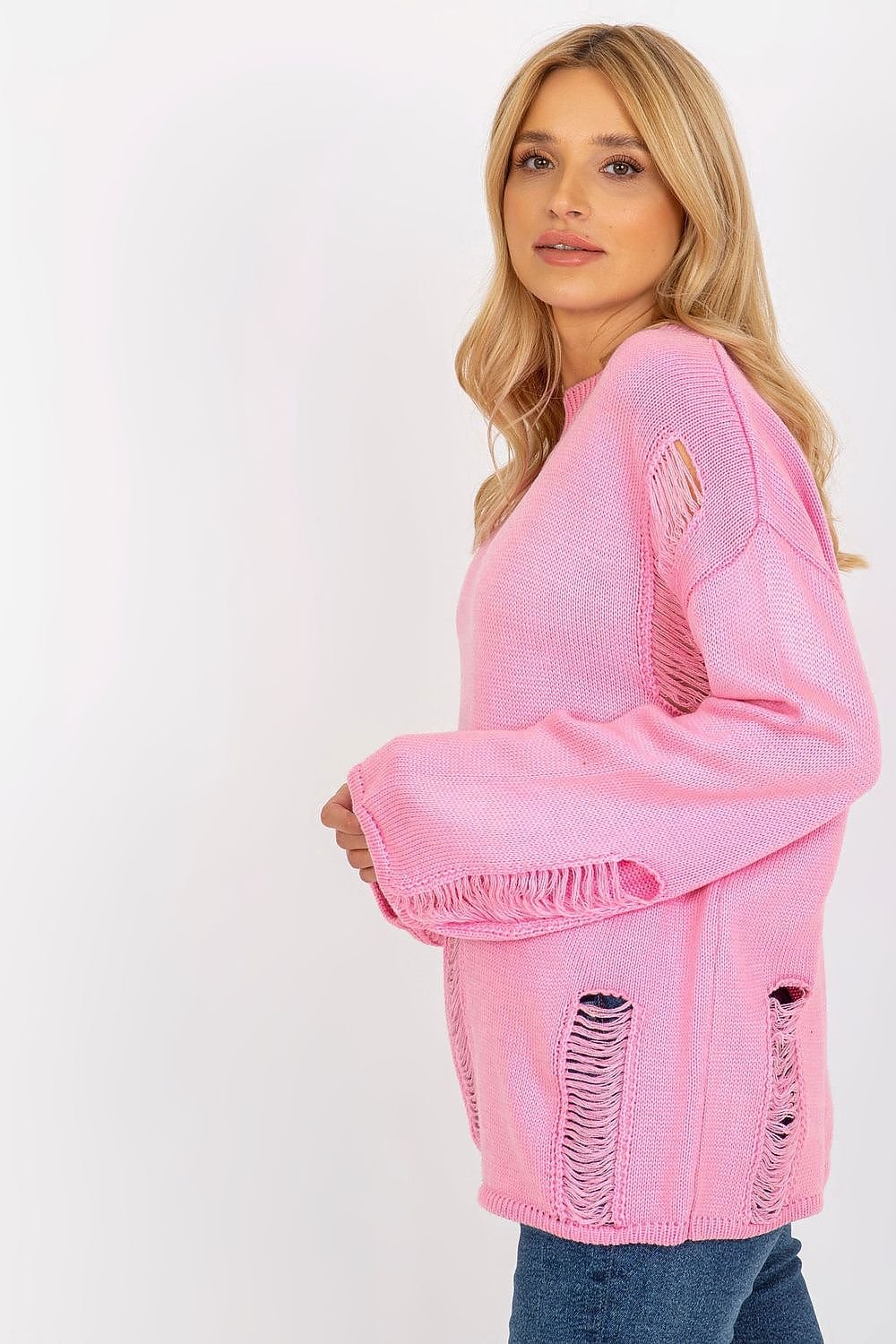 Cozy pink oversized jumper with distressed details, showcased on a blonde female model against a plain white background.