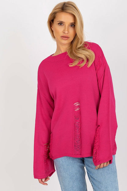 Vibrant pink oversized sweater with ripped details, modeled by a young woman with long blonde hair.