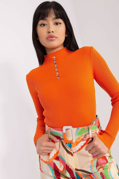 Vibrant retro-inspired ribbed knit top in bold orange hue, featuring a high neckline and button detail, worn by a young woman with dark hair against a plain background.