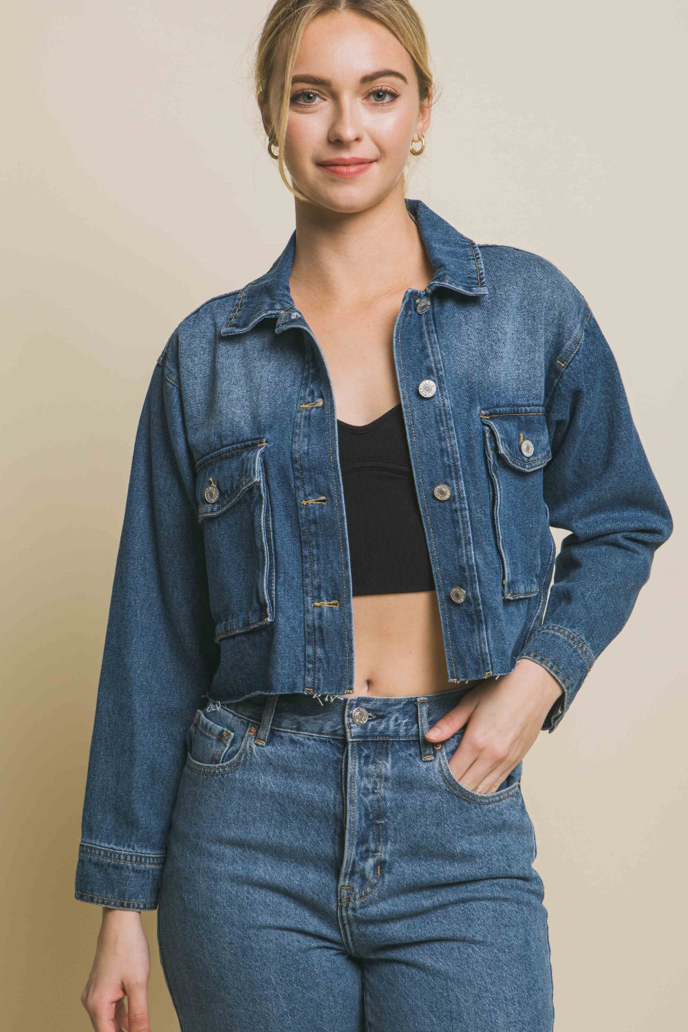 Raw Hem Button Up Cropped Denim Jacket - Stylish blue denim jacket with a raw hem and button closure showcased on a female model.