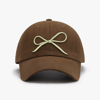 Elegant cotton baseball cap with a bow embroidered design in a neutral brown color, perfect for casual and stylish everyday wear.