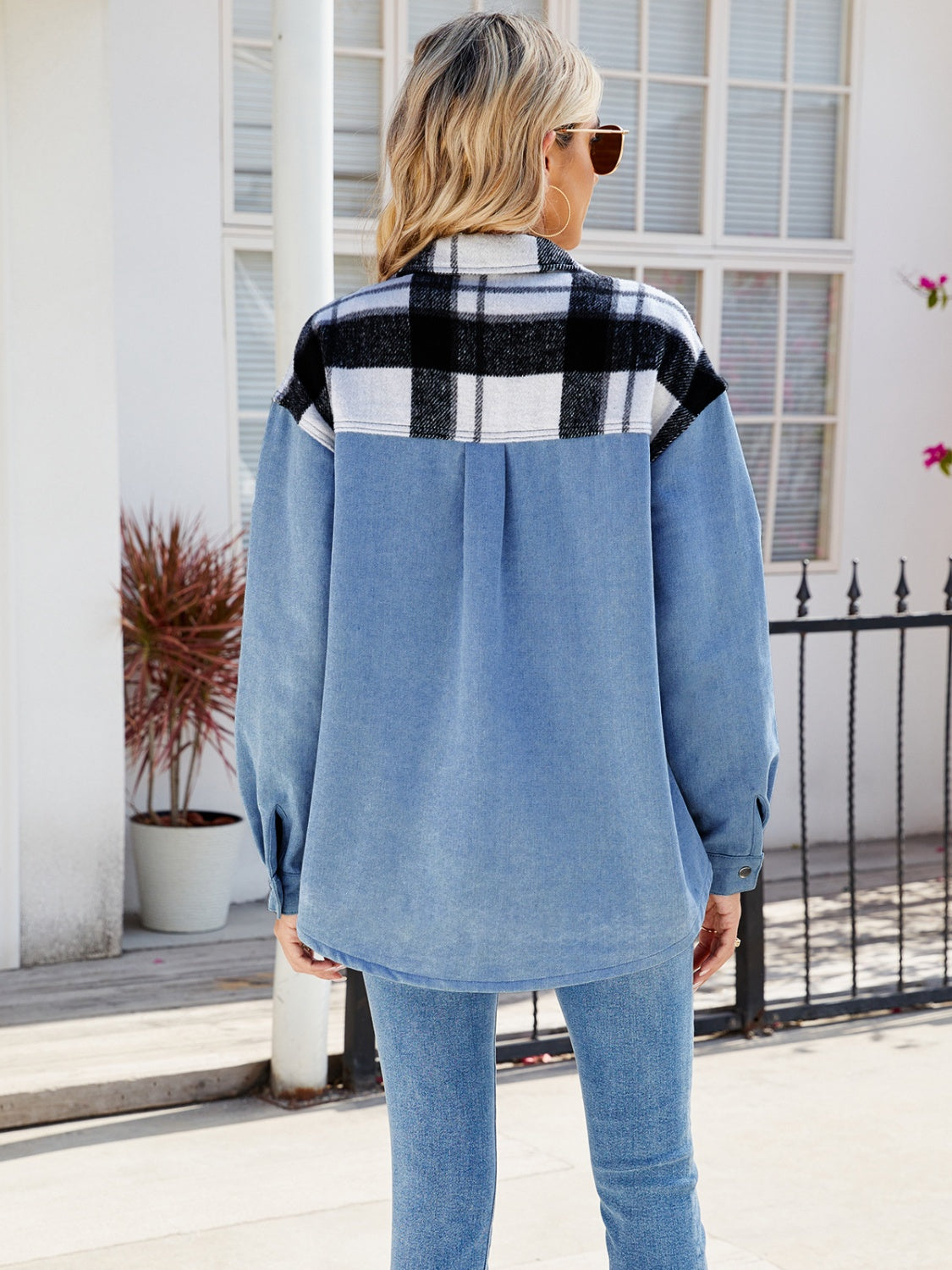 Stylish plaid and denim jacket with pockets, worn by a woman with blonde hair outdoors near a building.