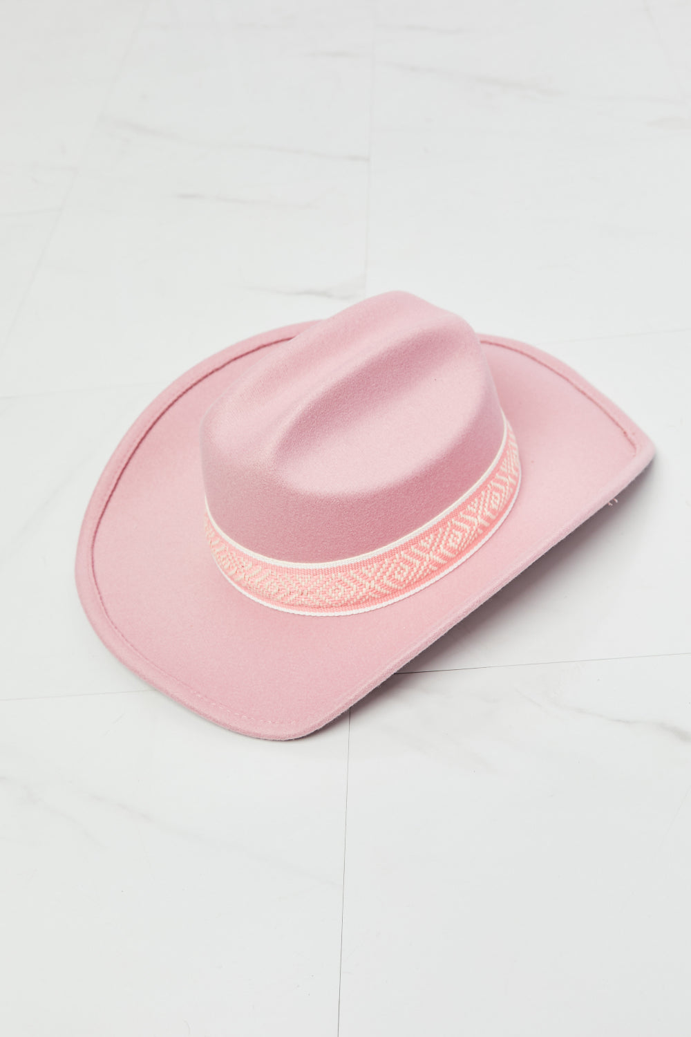 Fashionable pink cowboy hat with intricate woven design trim