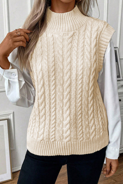 Cozy cable knit sweater vest in neutral oatmeal tone, featuring a high neck design, ideal for transitional weather.