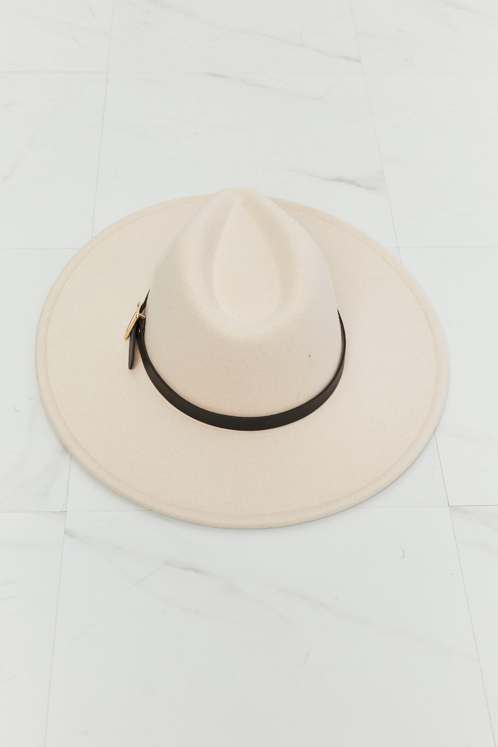 Elegant ivory fedora hat with black band, minimal chic accessory for fashion-forward look.