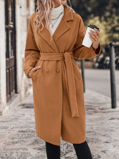 Camel brown belted trench coat with dropped shoulders and tie waist, worn by a fashionable woman on a city street