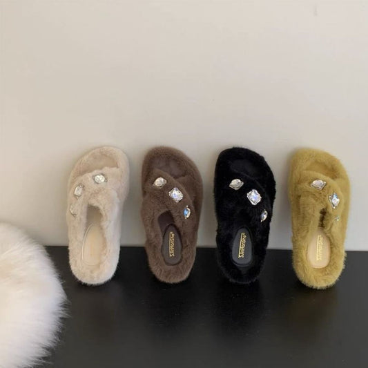 Rhinestone-embellished open-toe plush slippers in a variety of neutral colors, displayed on a dark surface.