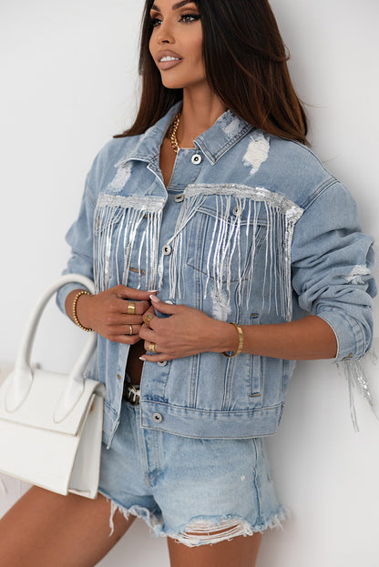 Fashionable distressed denim jacket with sequin fringe trim, showcased against a white background.