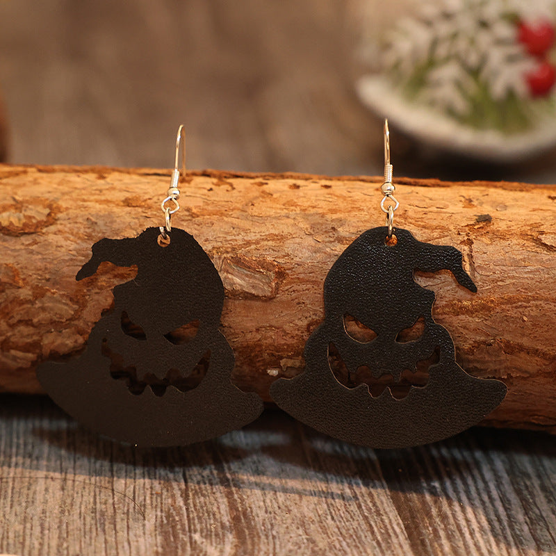 Trendy Halloween-themed PU leather hat shape earrings on a rustic wooden surface