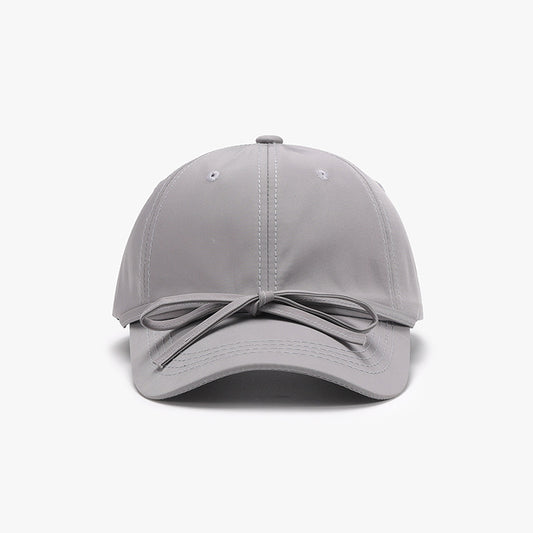 Sleek gray cotton baseball cap with a stylish tied bow accent feature, showcased against a plain white background.