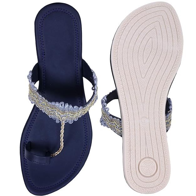 Ethnic embroidered women's navy blue sandals with a delicate metallic accent on the straps, resting on a textured white sole.