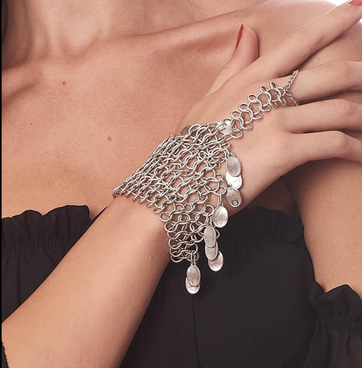 Elegant silver chain bracelet with cascading charms, a modern and stylish accessory for the fashion-forward woman.